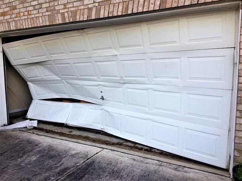 Damaged garage door evaluated for repair or replacement